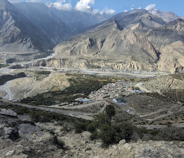 Stunning landscape of Mustang Nepal with dramatic cliffs, and desert-like terrain under clear blue sky